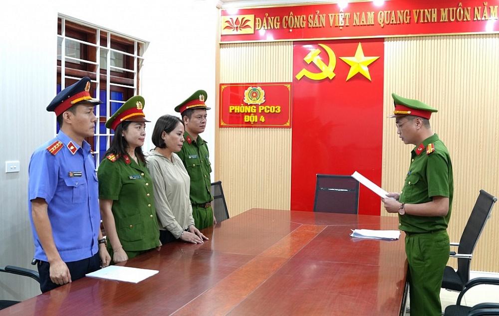 Công an tỉnh Nghệ An tống đạt quyết định và lệnh đối với Phan Thị Mai (không đội mũ).